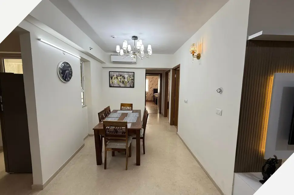 Elegant dining area with wooden table, chandelier, and modern decor in a Trisuka Project Pvt. Ltd. residential property.